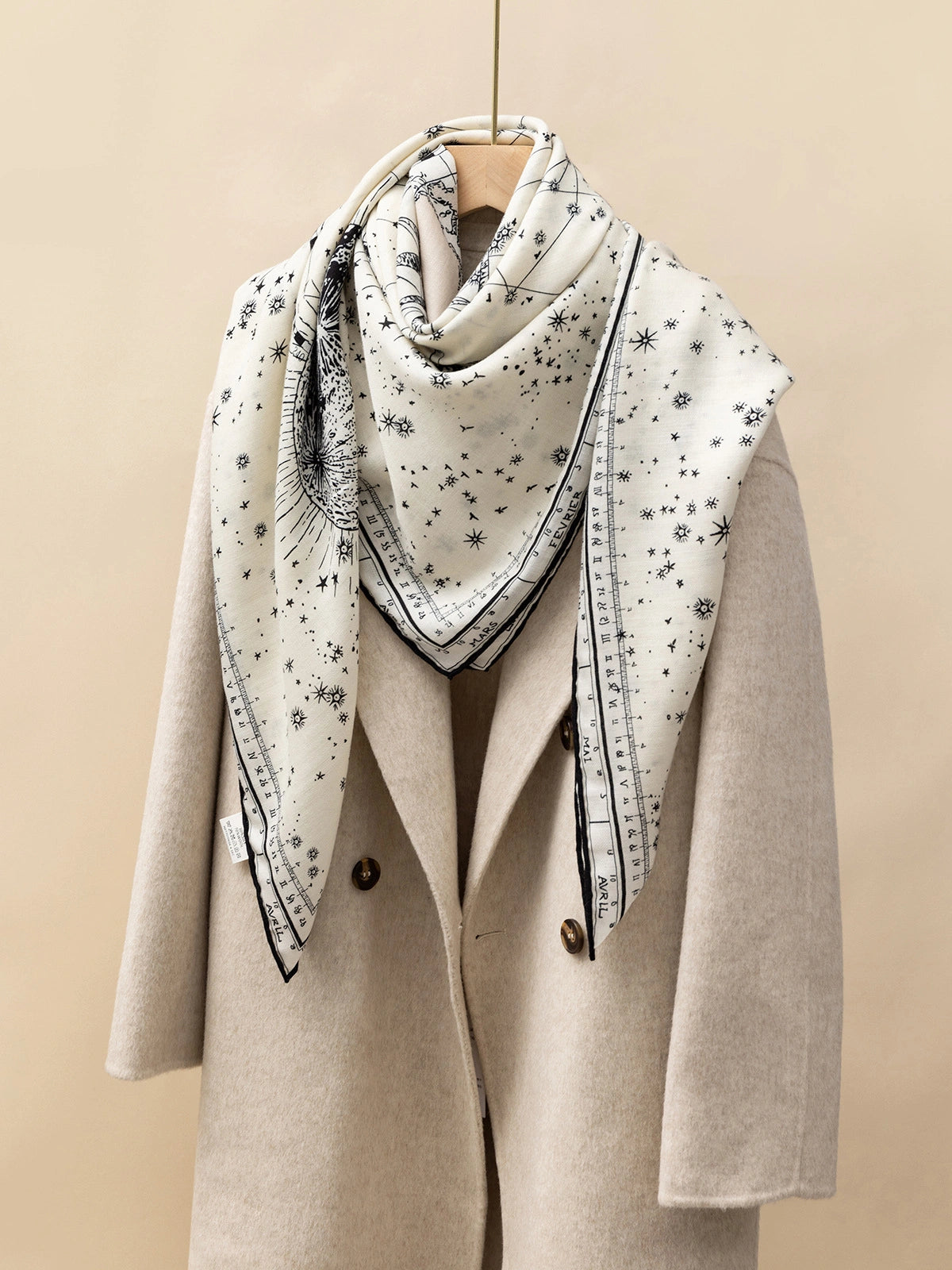Silk Wool Square Scarf - Cosmic Star Map Print | Beige, 130*130cm, draped on a coat, showcasing starry map pattern, stylish and luxurious accessory.