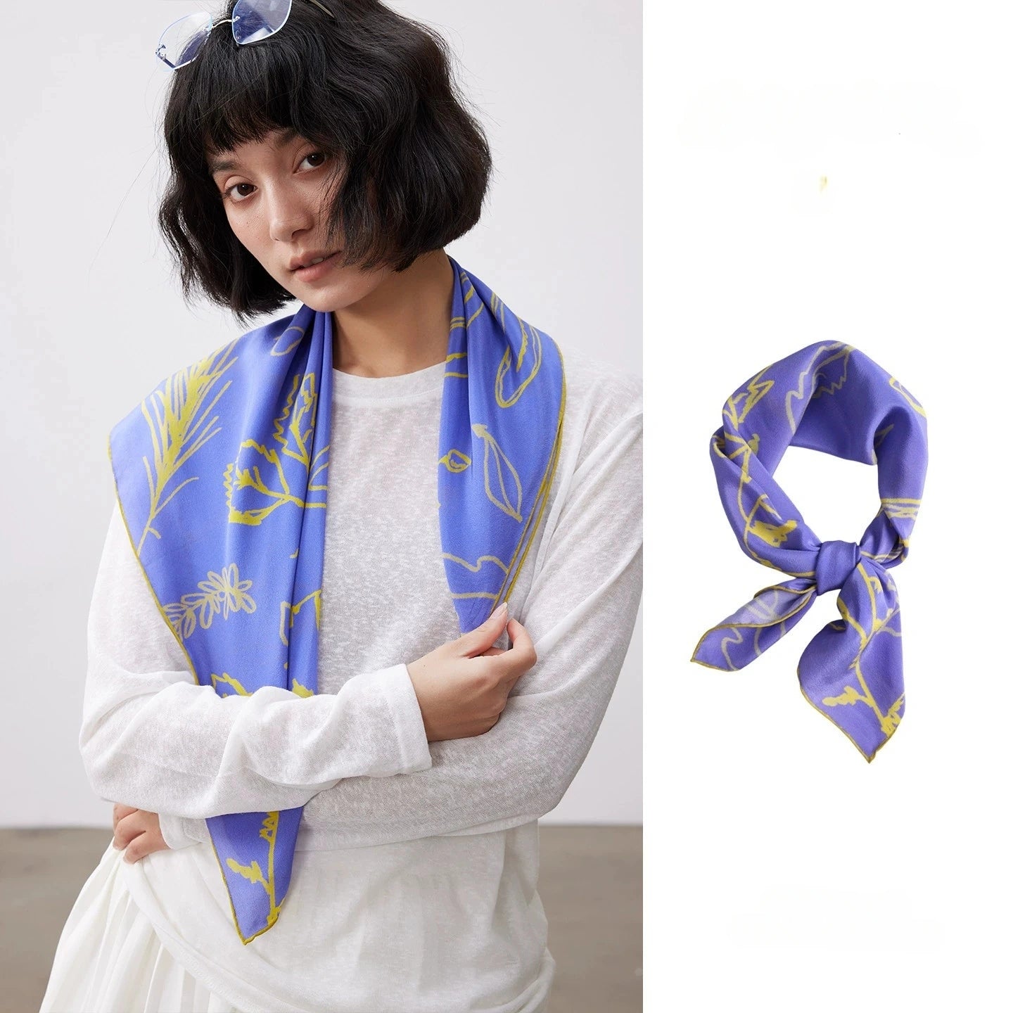 Blue silk square scarf (63x63cm) with yellow botanical print, tied into a bow, made from luxurious mulberry silk.