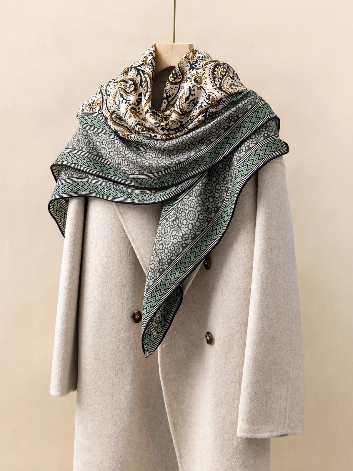 Silk Wool Square Scarf – Vintage Paisley Design | Green, 130*130cm, angled on coat, showcasing detailed paisley motifs, stylish and luxurious scarf.