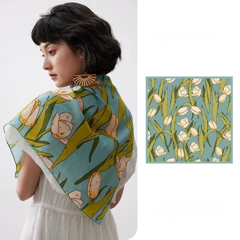 A green tulip floral print silk square scarf made from 100% mulberry silk is shown in a close-up.