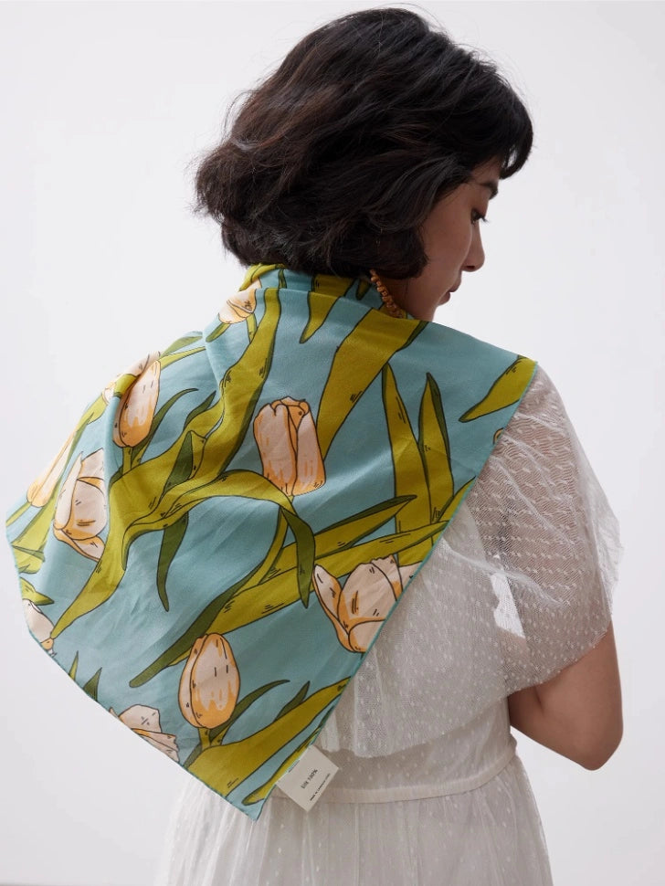 A green tulip floral print silk square scarf made from 100% mulberry silk is displayed as the back of the shawl.