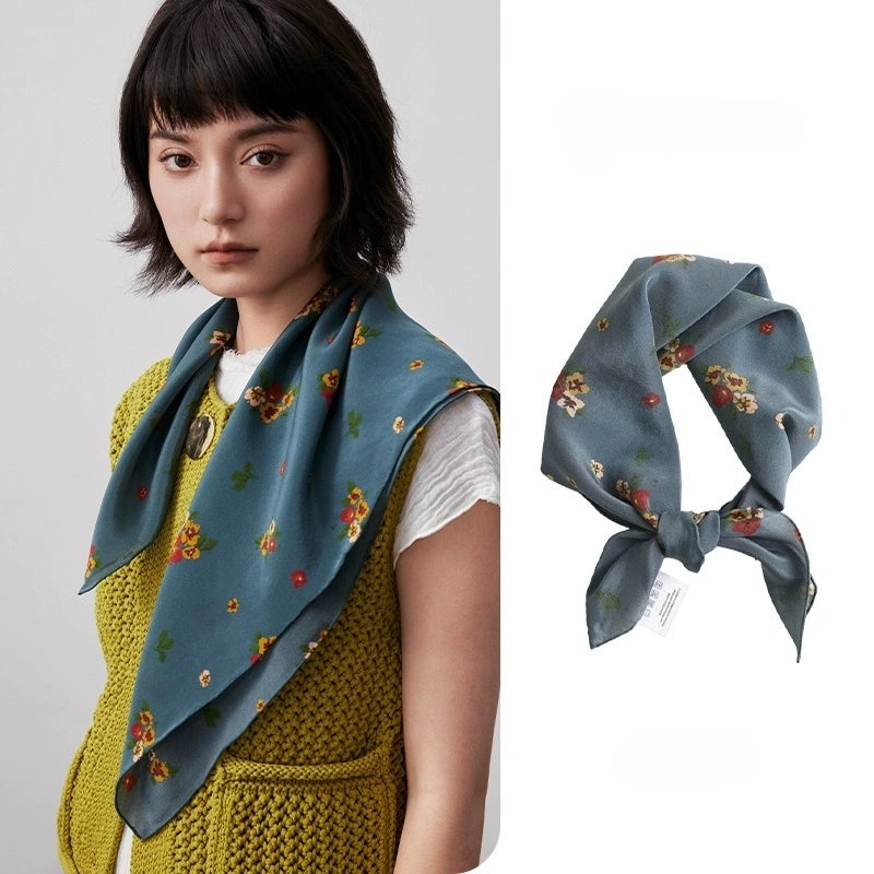 The model wore a Greenish-blue floral silk square scarf as a neck scarf, showcasing its elegance and versatility.