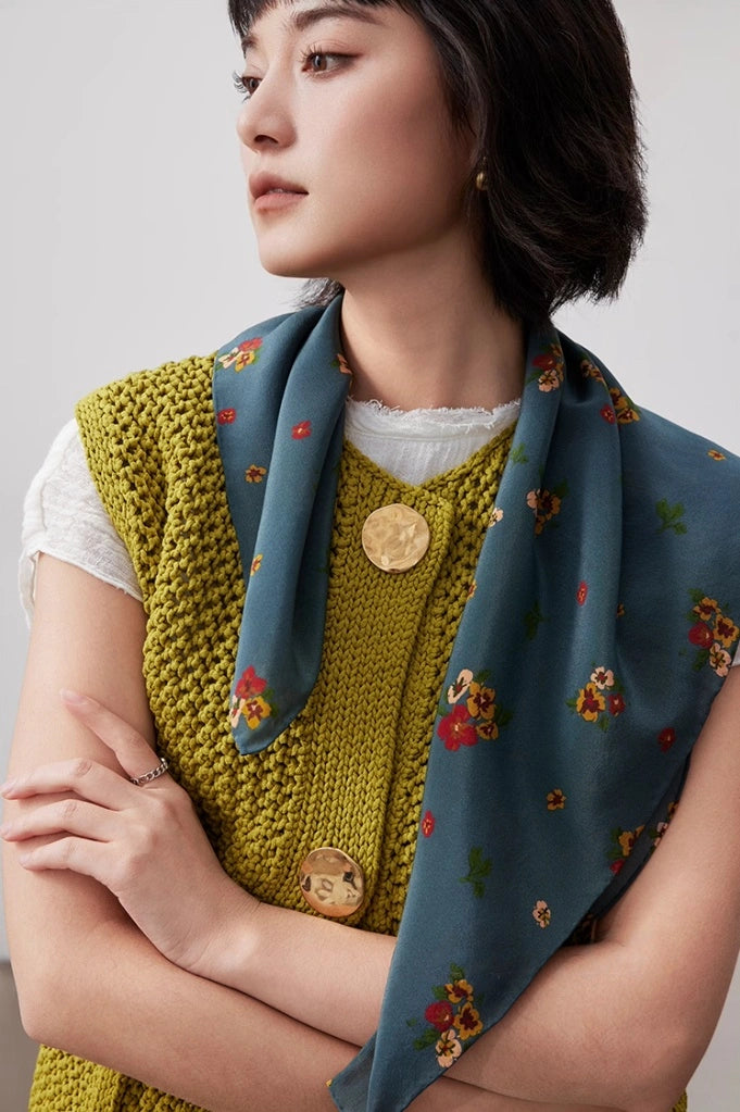 The model wears a Greenish-blue floral silk square scarf as a neck scarf, showcasing its elegance and versatility from the front.