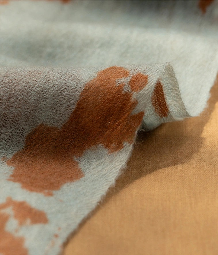 Detailed view of the tangerine cashmere scarf, showcasing its luxurious and soft cashmere material.
