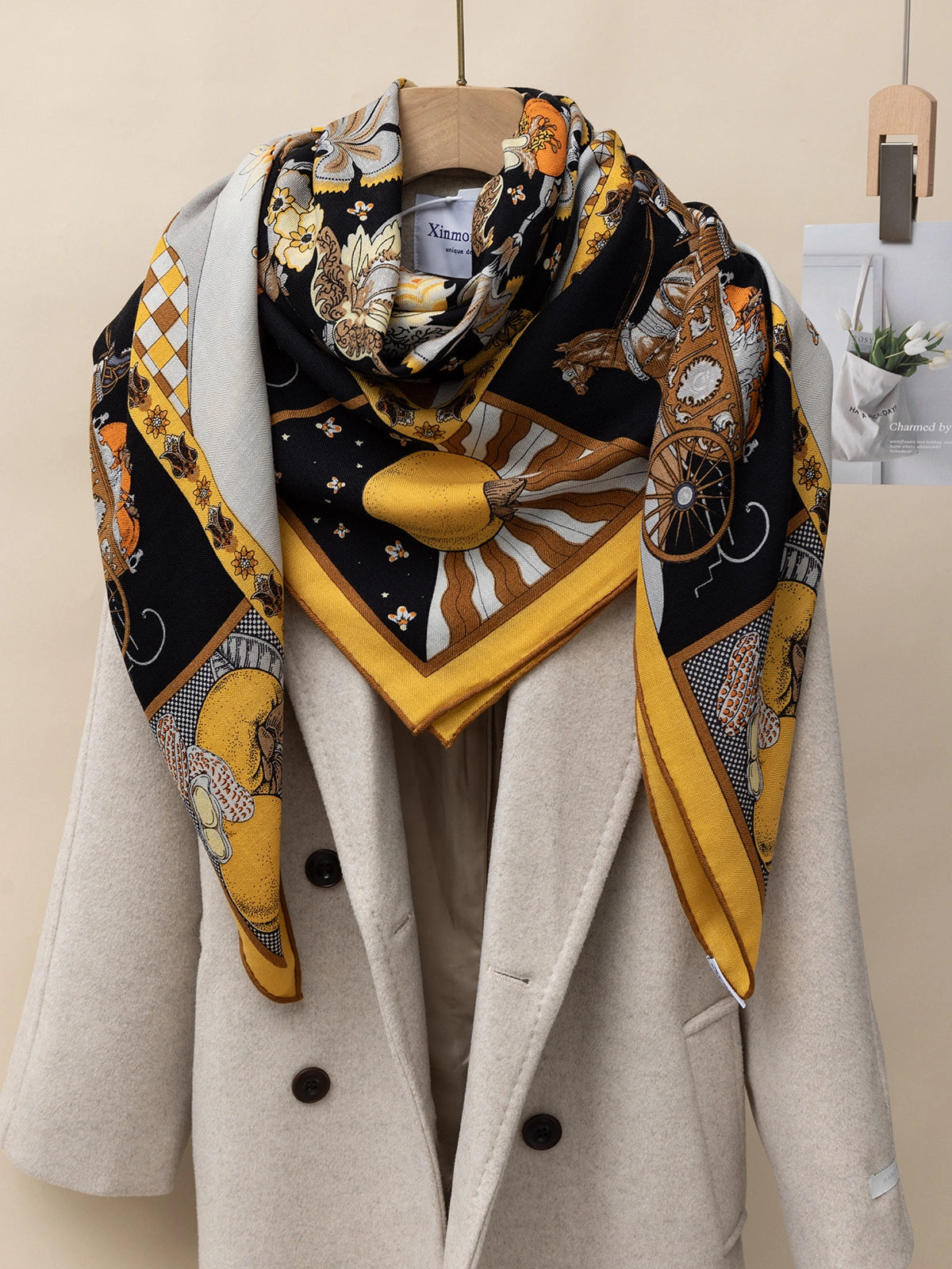 Silk-wool square scarf – Persimmon tree print | Yellow, 130 × 130 cm, draped over a coat to showcase a luxurious texture.