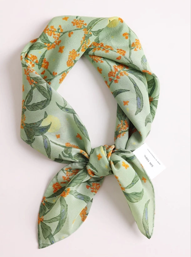 Close-up of green osmanthus silk scarf, showcasing the intricate floral print and luxurious texture.
