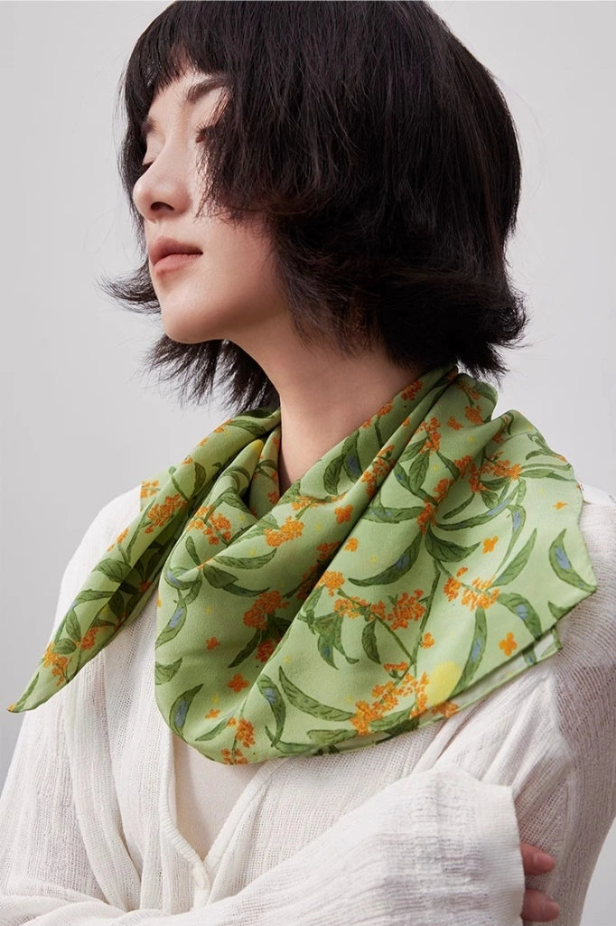 The model wears a green osmanthus silk square scarf as a neck accessory, showcasing its elegant temperament and versatile qualities from the side.