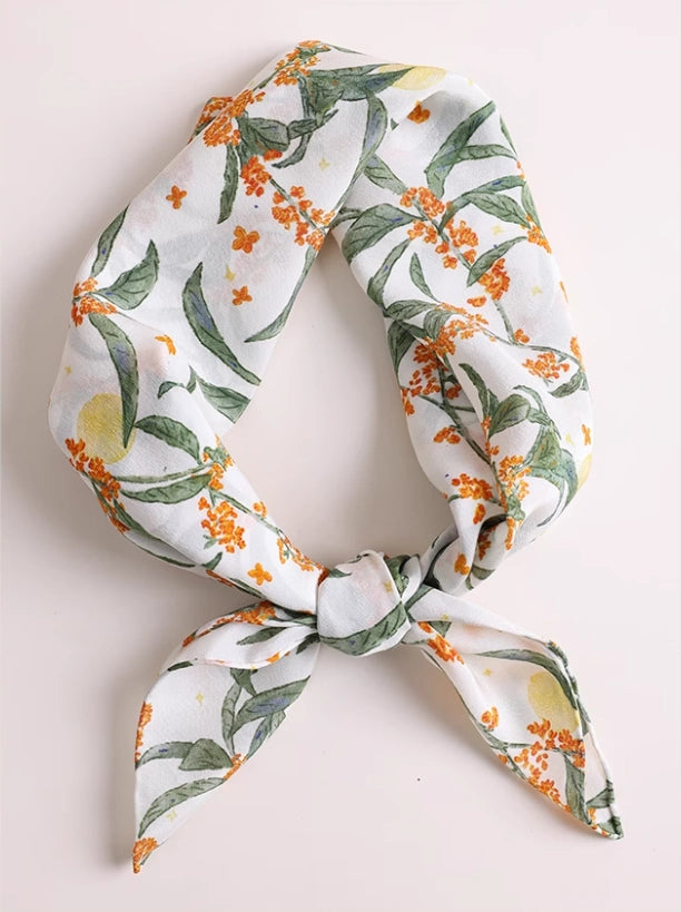 Close-up of white osmanthus silk scarf, showcasing the delicate floral print and luxurious texture.