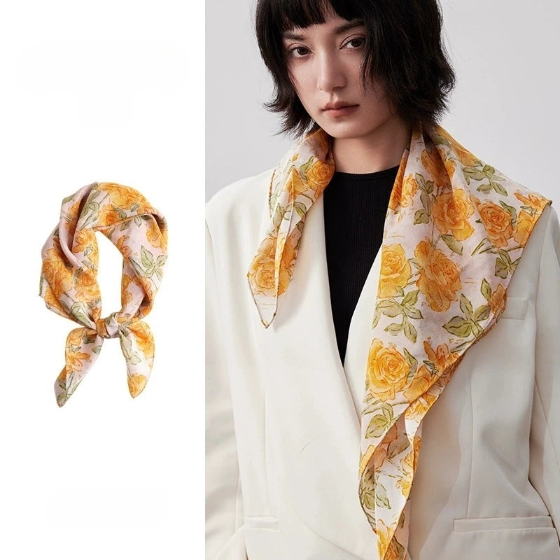 Elegant yellow rose print silk square scarf, 100% mulberry silk, displayed flat to showcase its vibrant floral design and smooth texture.