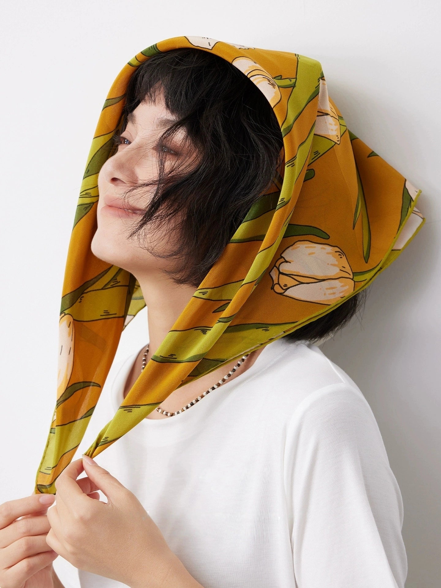 A yellow tulip floral print silk square scarf made from 100% mulberry silk, shown as a close-up headscarf.